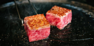 Cubes of wagyu beef cooked on a grill